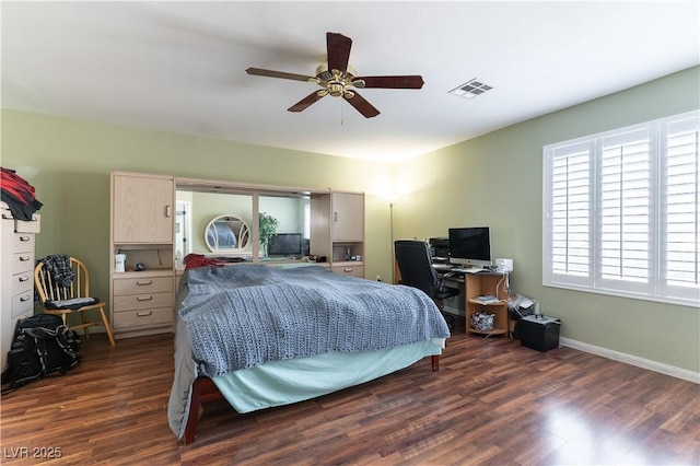 bedroom with dark wood-style floors, visible vents, ceiling fan, and baseboards