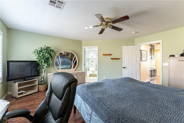 bedroom with a ceiling fan, wood finished floors, visible vents, baseboards, and ensuite bath