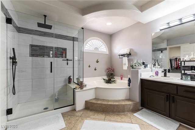 bathroom featuring tile patterned floors, vanity, a garden tub, and a shower stall