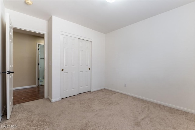 unfurnished bedroom with a closet, baseboards, and carpet floors