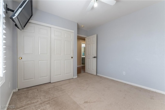 unfurnished bedroom featuring a closet, ceiling fan, baseboards, and carpet