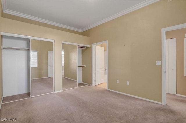 unfurnished bedroom featuring ornamental molding, light carpet, two closets, and connected bathroom