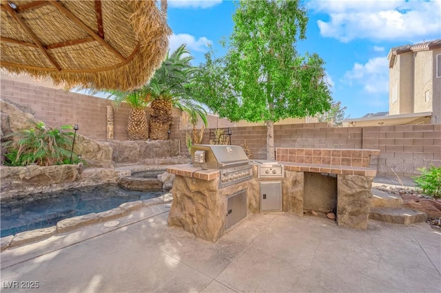 view of patio with grilling area and an outdoor kitchen