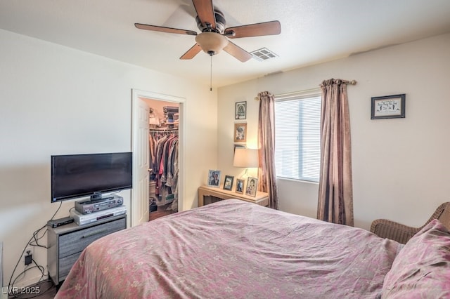 bedroom with ceiling fan, a spacious closet, and a closet