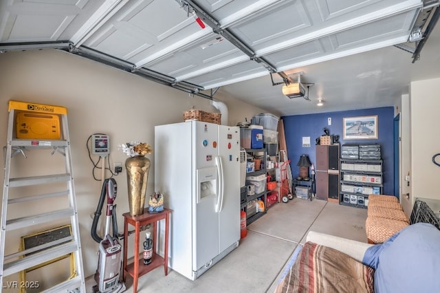 garage featuring a garage door opener and white refrigerator with ice dispenser