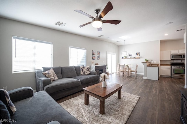 living room with sink, dark hardwood / wood-style floors, and ceiling fan