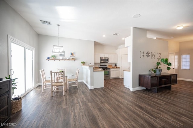 dining space featuring dark hardwood / wood-style flooring and vaulted ceiling