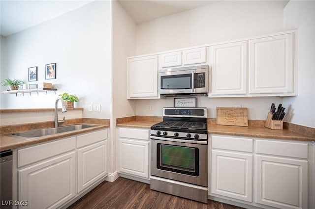 kitchen featuring stainless steel appliances, white cabinetry, sink, and dark wood-type flooring