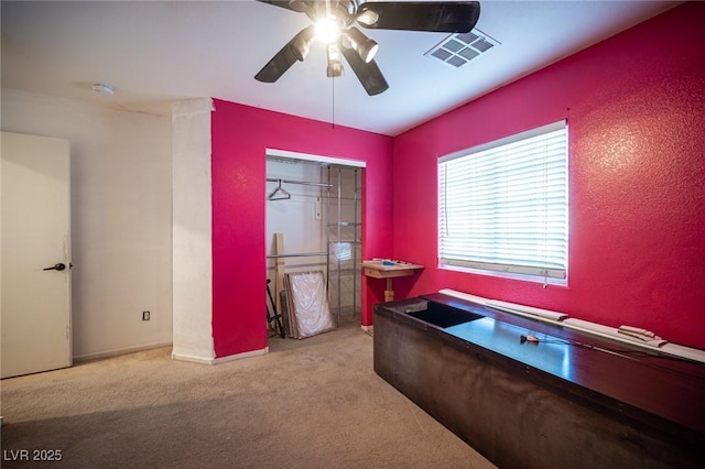 carpeted home office with ceiling fan