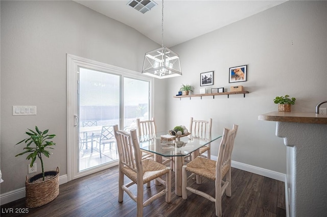 dining room with an inviting chandelier and dark wood-type flooring