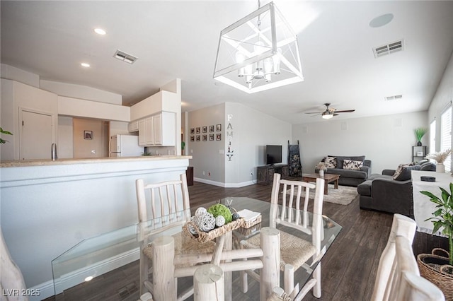 dining area featuring sink, ceiling fan with notable chandelier, and dark hardwood / wood-style floors