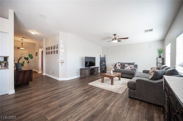 living room with dark wood-type flooring and ceiling fan