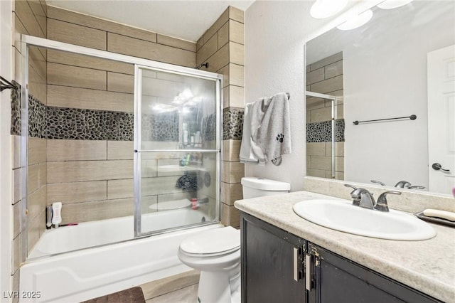 full bathroom with vanity, toilet, and combined bath / shower with glass door