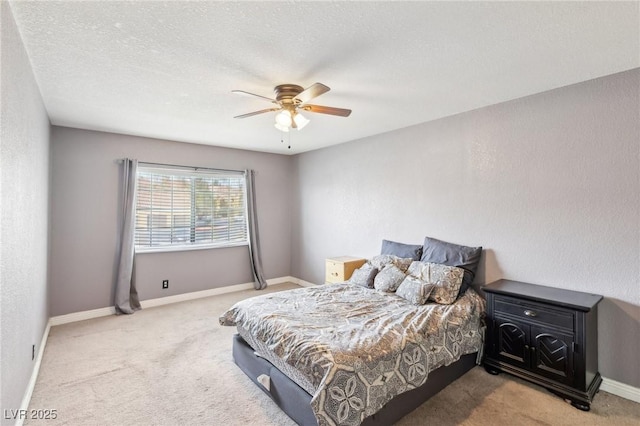 carpeted bedroom featuring ceiling fan and a textured ceiling