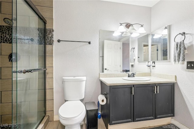 bathroom featuring walk in shower, vanity, and toilet