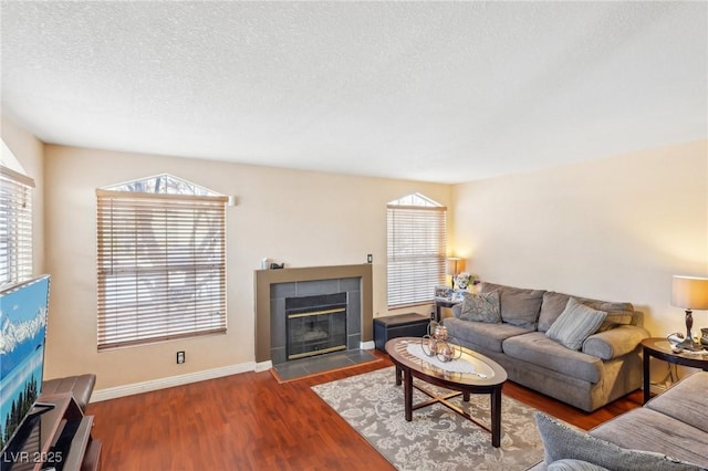 living room featuring a textured ceiling, a fireplace, and wood-type flooring