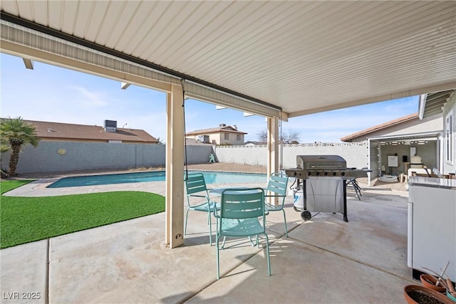 view of patio with area for grilling and a fenced in pool