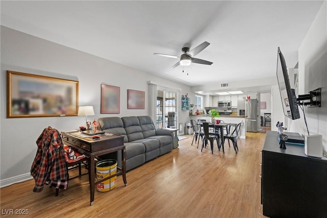 living room featuring ceiling fan and light wood-type flooring