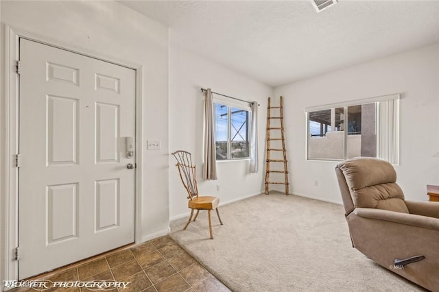 sitting room with a textured ceiling and dark carpet