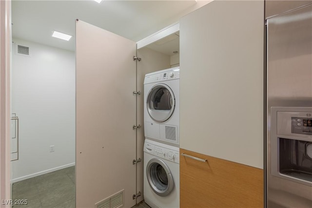 clothes washing area featuring stacked washer and dryer