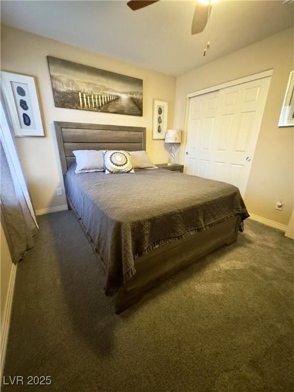 bedroom featuring dark colored carpet, ceiling fan, and a closet