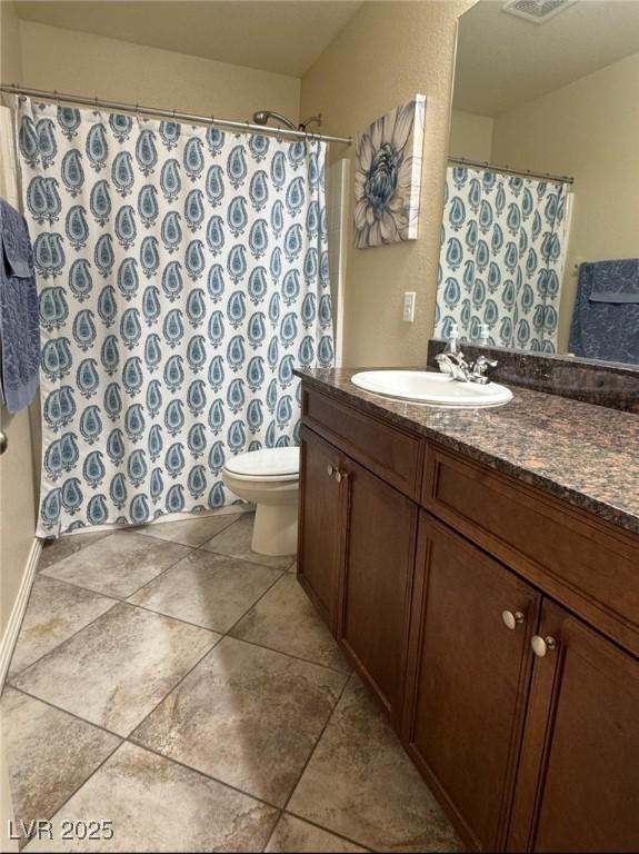 bathroom featuring vanity, tile patterned floors, and toilet