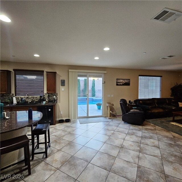 living room featuring sink and light tile patterned floors