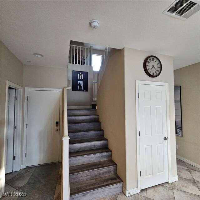 stairway with tile patterned flooring