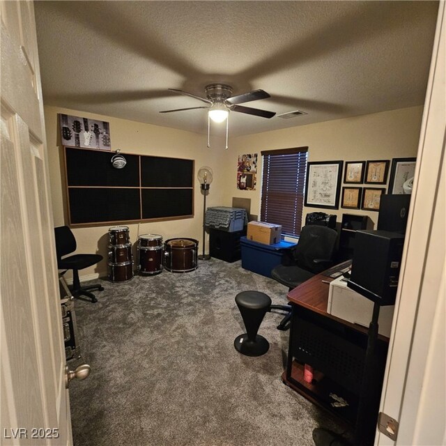 carpeted office space with ceiling fan and a textured ceiling