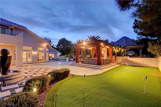 yard at dusk with outdoor lounge area and a patio area