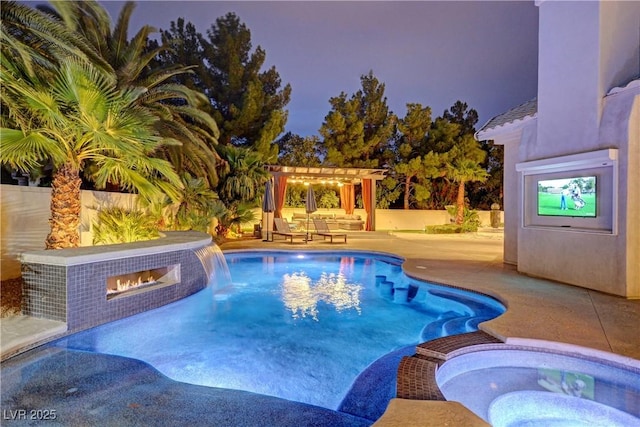 pool at dusk with an in ground hot tub, a fireplace, a pergola, and a patio area