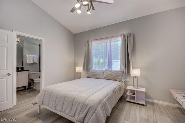 bedroom featuring ceiling fan, connected bathroom, vaulted ceiling, and light hardwood / wood-style flooring