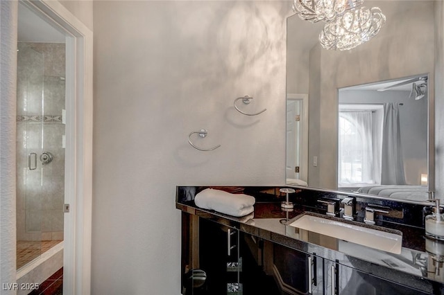 bathroom with vanity, an inviting chandelier, and walk in shower