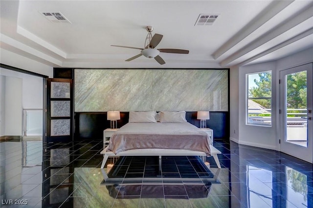 bedroom featuring a raised ceiling and access to outside