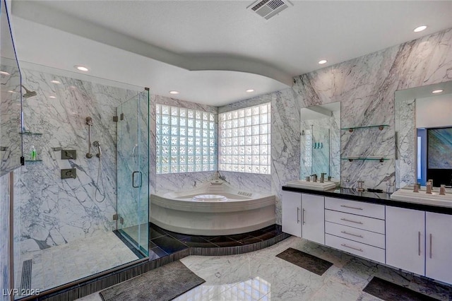 bathroom featuring independent shower and bath, vanity, and tile walls