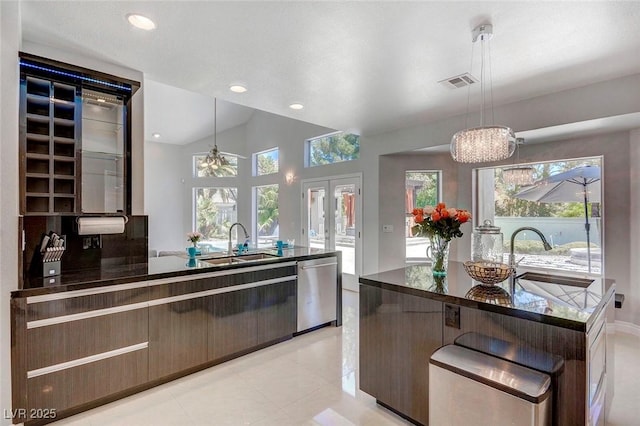 kitchen featuring pendant lighting, stainless steel dishwasher, sink, and french doors