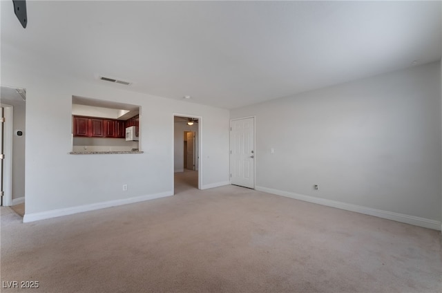 spare room featuring light colored carpet and ceiling fan