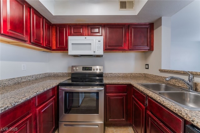 kitchen with light stone counters, sink, and stainless steel electric range