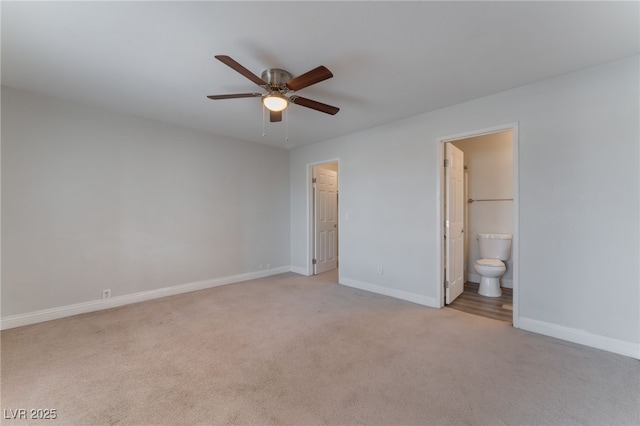 unfurnished bedroom with ceiling fan, light colored carpet, and ensuite bath