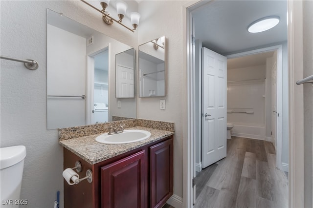 bathroom featuring vanity, toilet, and hardwood / wood-style floors