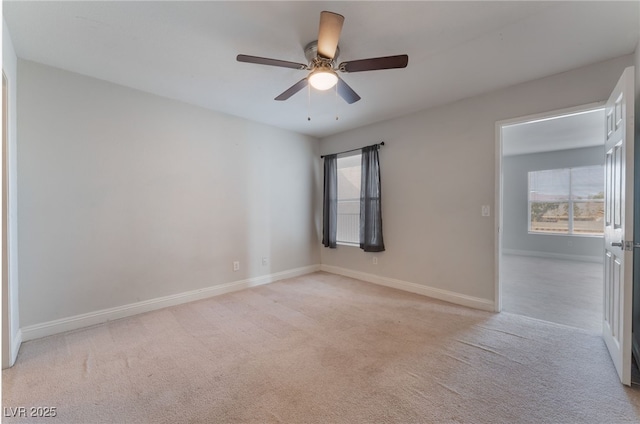 empty room featuring light colored carpet and ceiling fan