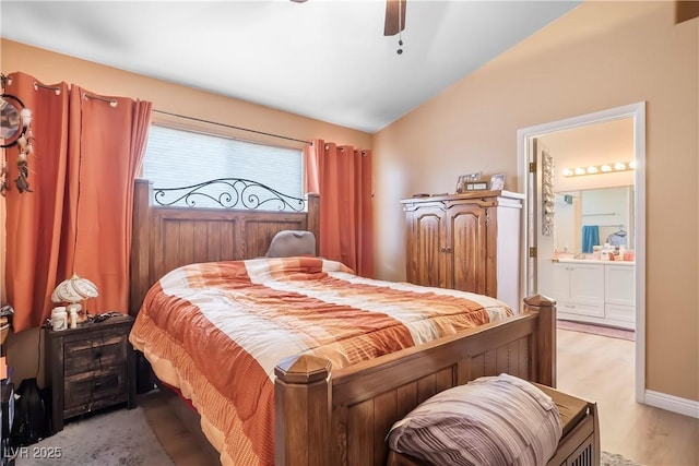 bedroom with ensuite bathroom, lofted ceiling, ceiling fan, and light hardwood / wood-style flooring