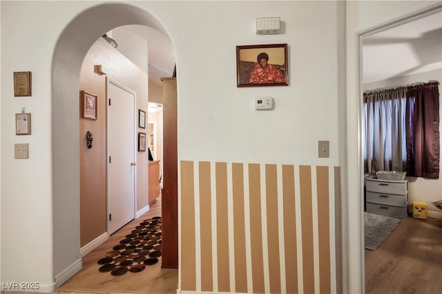 corridor with hardwood / wood-style flooring