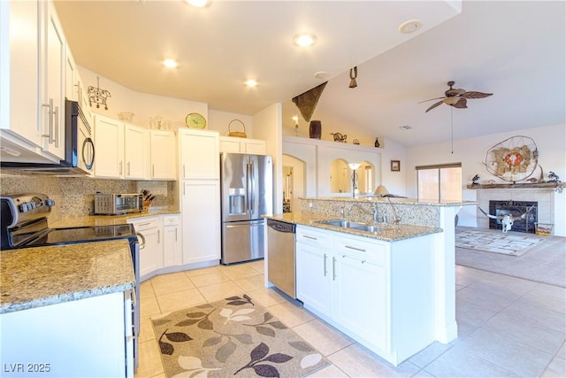 kitchen with sink, stainless steel appliances, an island with sink, and white cabinets