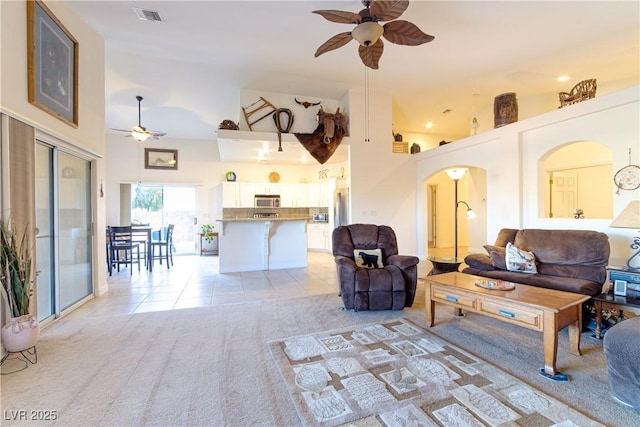 living room featuring light tile patterned flooring, ceiling fan, and high vaulted ceiling