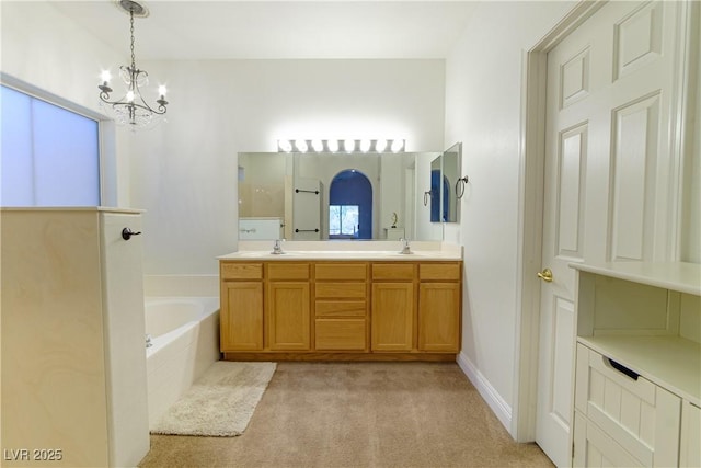 bathroom with vanity, tiled bath, and an inviting chandelier