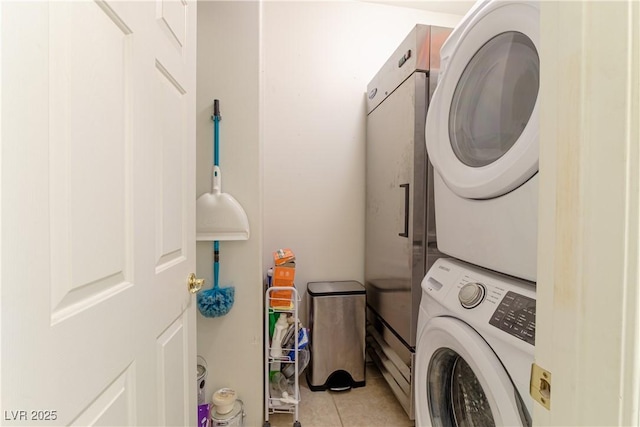 washroom with light tile patterned flooring and stacked washer and clothes dryer