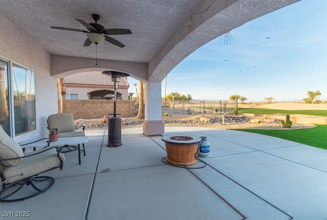 view of patio featuring ceiling fan and an outdoor fire pit