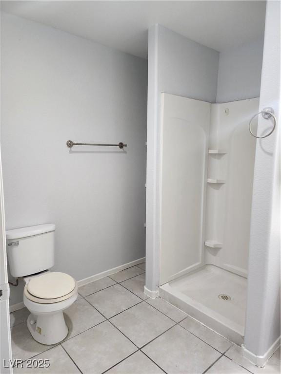 bathroom with tile patterned flooring, toilet, and walk in shower