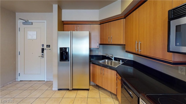 kitchen with appliances with stainless steel finishes, sink, and light tile patterned floors